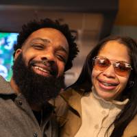 Man with beard and woman with sun galsses standing together and smiling for camera